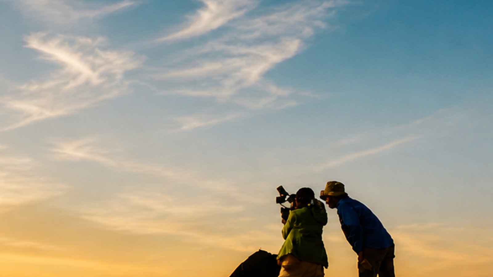 Finn Chen on location with a visible crew figure and sunset light